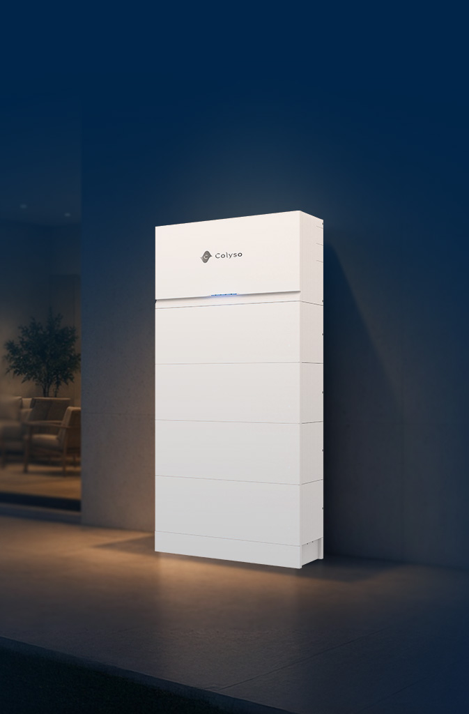 Batterie de stockage Colyso fixée au mur extérieur d’une maison, à la tombée de la nuit